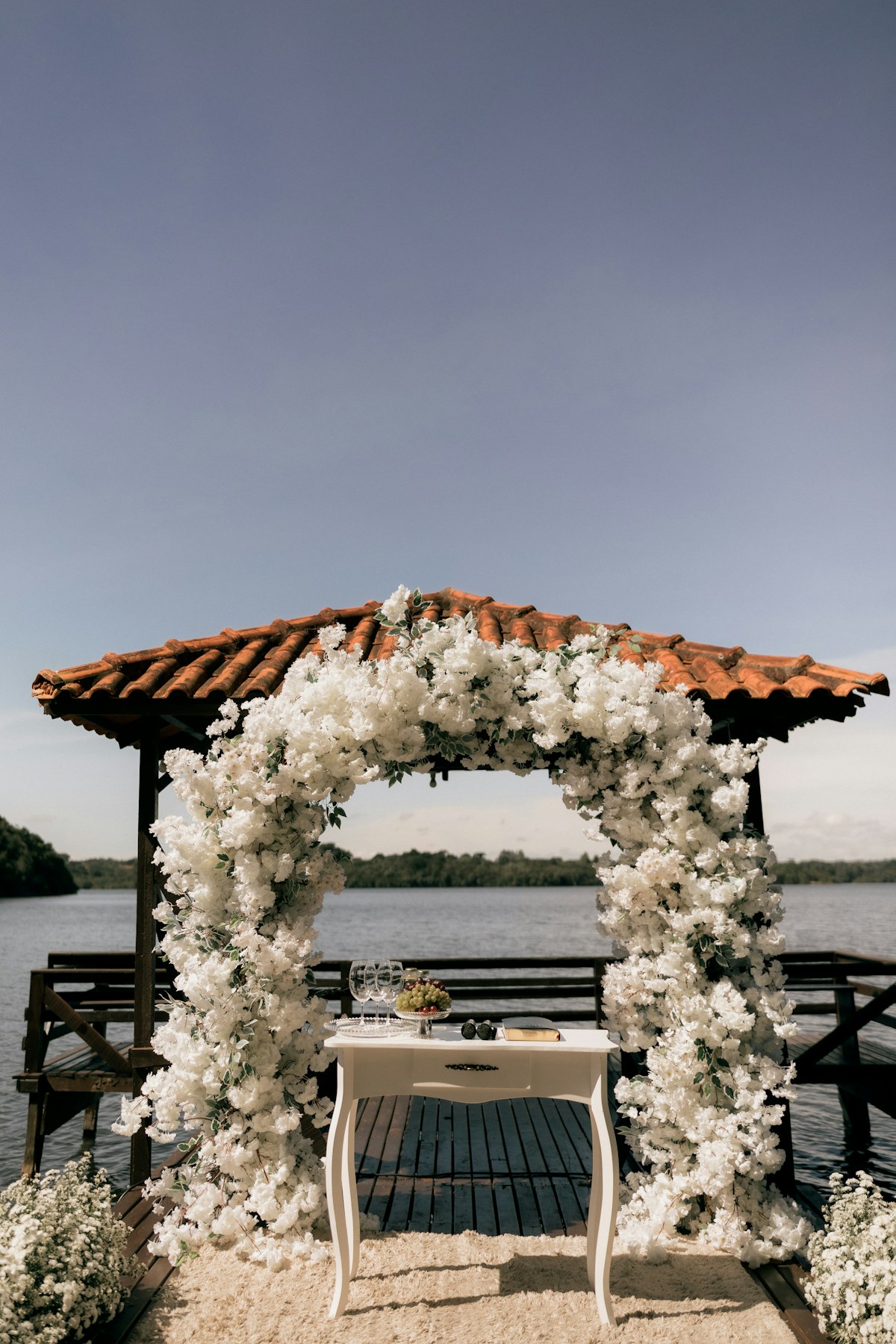 Свадебная церемония у воды с белыми цветами